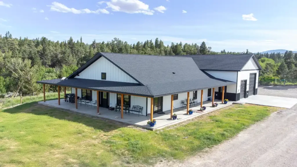 Montana pole barns showcased in the Spokane Ranch Barndominium with attached garage and wraparound porch.